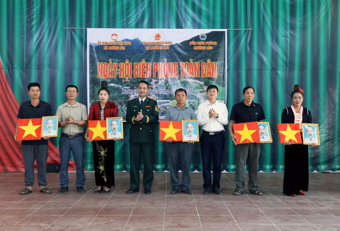 Tặng cờ Tổ quốc và ảnh Bác Hồ cho các đại diện các bản thuộc xã Mường Lèo.