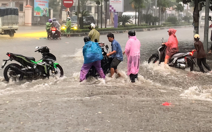 Người tham gia giao thông bị dòng nước chảy xiết xô ngã tại nút giao Bà Triệu - Phan Đình Phùng (đường Hồ Chí Minh đoạn qua phường Kon Tum) trong cơn mưa chiều 10/8/2025. Người tham gia giao thông bị dòng nước chảy xiết xô ngã tại nút giao Bà Triệu - Phan Đình Phùng (đường Hồ Chí Minh đoạn qua phường Kon Tum) trong cơn mưa chiều 10/8/2025.