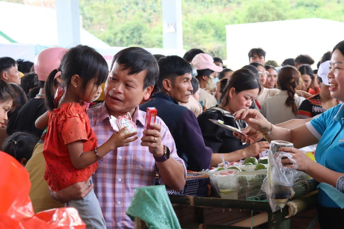 Phó Bí thư Đảng ủy, Chủ tịch UBND xã Tu Mơ Rông Trần Quốc Huy tặng quà cho trẻ em nghèo Xê Đăng. Ảnh: TTXVN phát phien-cho-0-dong-4.jpg