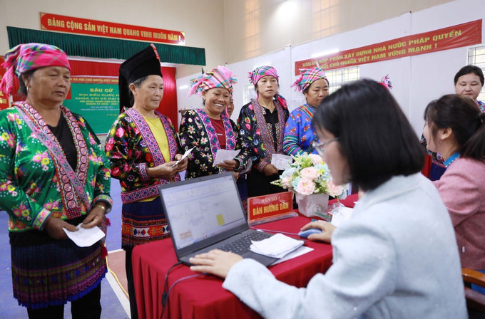 Cử tri bản Nậm Sảo 2 vui mừng đến làm thủ tục bỏ phiếu bầu cử tại khu vực bỏ phiếu số 3, bản Nậm Sảo 2, xã biên giới Pa Tần. Ảnh: Quý Trung/TTXVN