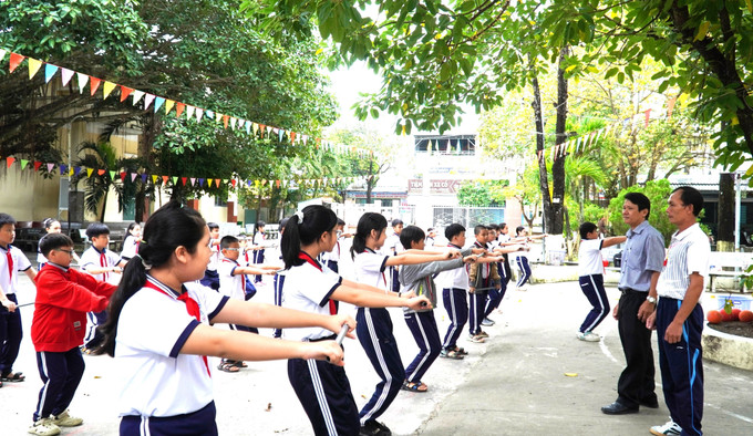 Thầy Phùng Nhật Dũng (thứ 2, phải sang), Hiệu trưởng Trường Tiểu học Dương Đông 4, đặc khu Phú Quốc trong giờ dạy thể dục.