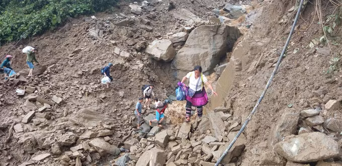 Người dân đi bộ qua khu vực sạt lở tại đèo Khau Phạ. Ảnh: TTXVN phát