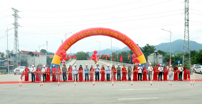 Các đại biểu thực hiện nghi thức cắt băng khánh thành tuyến đường. tuyen-duong-tranh-thi-tran-son-duong-3.jpg