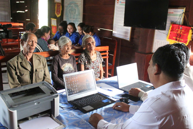 Cán bộ Trung tâm phục vụ hành chính công xã Ya Ly hướng dẫn người dân nộp hồ sơ tại buổi tiếp nhận thủ tục hành chính lưu động.