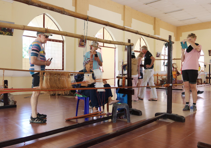 Du khách nước ngoài tham quan, tìm hiểu quy trình dệt thổ cẩm tại Hợp tác xã Dệt thổ cẩm Chăm Mỹ Nghiệp (xã Ninh Phước).