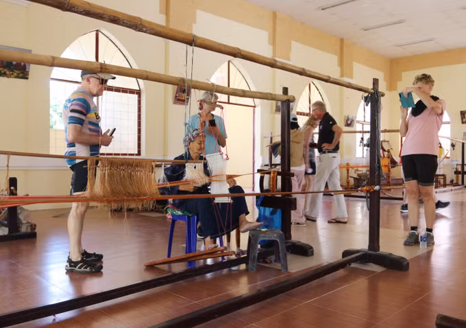 Du khách nước ngoài tham quan, tìm hiểu quy trình dệt thổ cẩm tại Hợp tác xã Dệt thổ cẩm Chăm Mỹ Nghiệp (xã Ninh Phước).