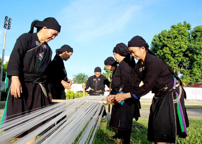 Trong công đoạn kéo sợi, phụ nữ La Chí sẽ trải sợi cho mượt mà, kéo đều tay, uyển chuyển để có sợi chỉ đều nhau. Ảnh: tuyengiao.hagiang.gov.vn