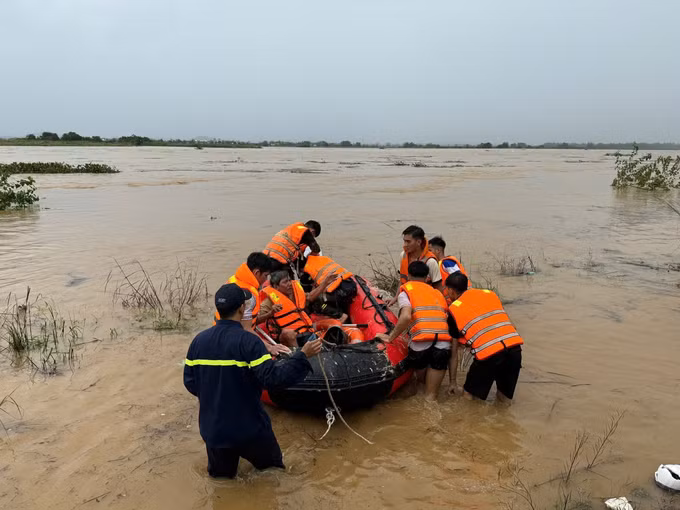 Lực lượng Cảnh sát phòng cháy chữa cháy Công an tỉnh Quảng Ngãi cưỡng chế đưa người dân giữa dòng sông Trà Khúc vào bờ. Ảnh: TTXVN