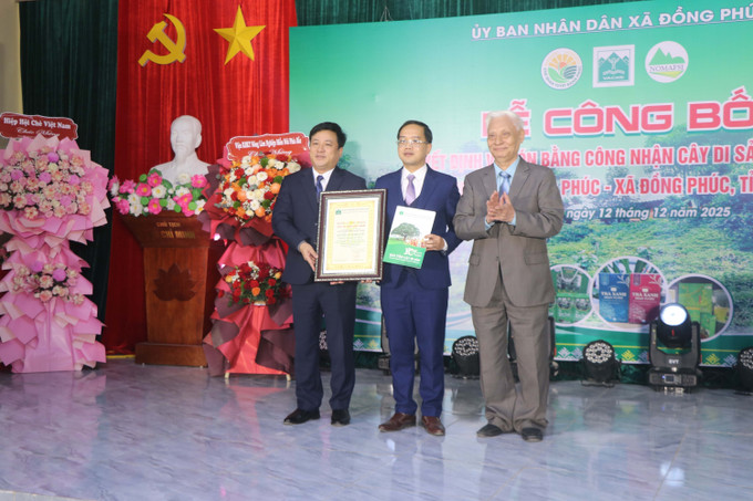 Tiến sỹ Nguyễn Ngọc Sinh (phải), Chủ tịch Hội Bảo vệ Thiên nhiên và Môi trường Việt Nam, trao Bằng công nhận Cây Di sản Việt Nam đối với quần thể 12 cây chè Shan tuyết tại xã Đồng Phúc.