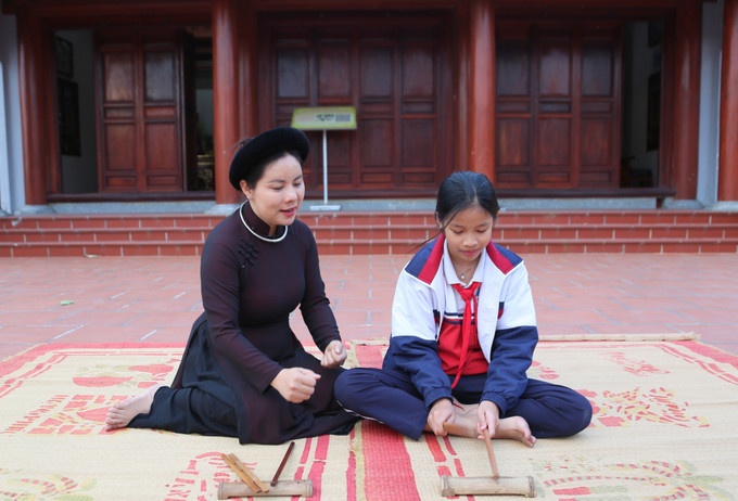 Cô giáo, ca nương Trịnh Thị Hoài Nam hướng dẫn học sinh Vũ Vân Anh, Trường Tiểu học Hòa Bình, gõ phách.