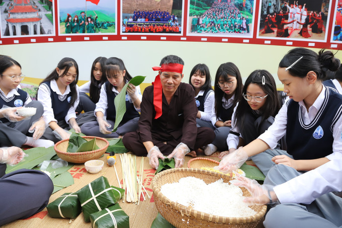 Học sinh được nghệ nhân dân gian hướng dẫn gói bánh truyền thống, tìm hiểu phong tục, tập quán và tri thức dân gian trong Chương trình Du lịch học đường - Giáo dục di sản văn hóa vùng Đất Tổ.