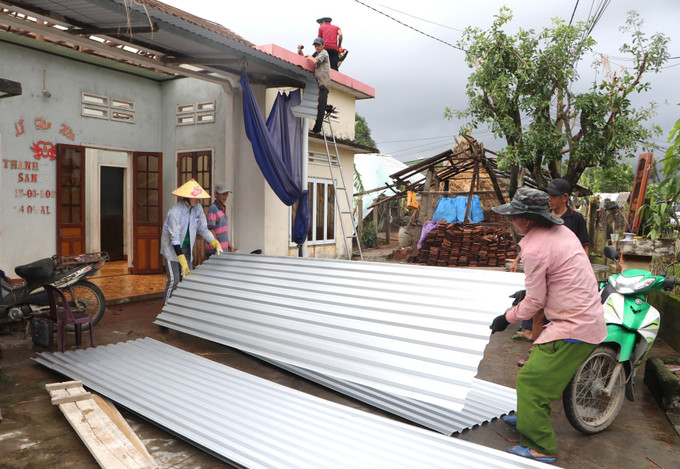Người dân khẩn trương lợp lại mái nhà.