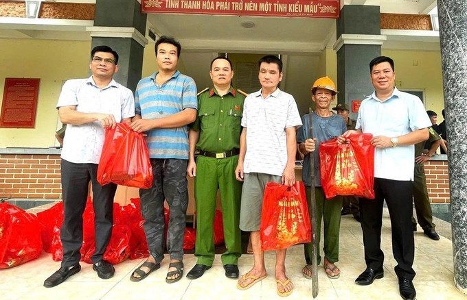 Người dân nhận những phần quà từ lực lượng công an sau khi giao nộp vũ khí. Ảnh: TTXVN phát