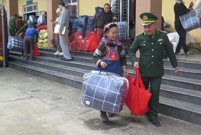 Người dân phấn khởi khi được cán bộ Biên phòng hỗ trợ nhận quà Tết.