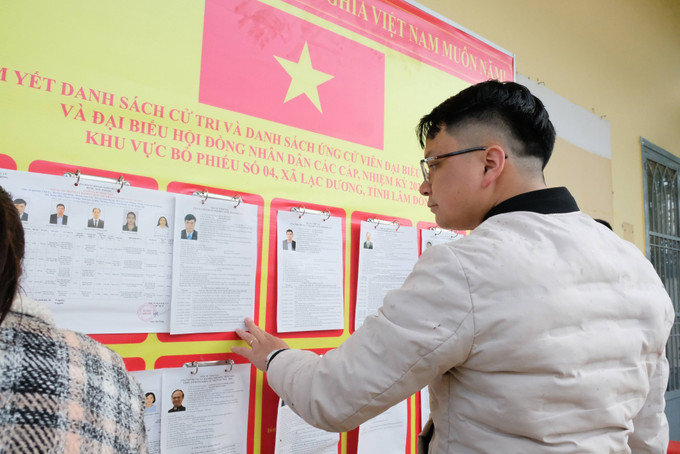 Cử tri theo dõi thông tin trên danh sách các ứng cử viên đại biểu Quốc hội khóa XVI và đại biểu Hội đồng nhân dân các cấp tại khu vực bỏ phiếu số 4 (xã Lạc Dương, Lâm Đồng).