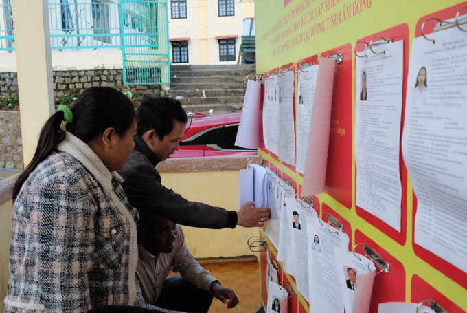 Các cử tri theo dõi thông tin trên danh sách các ứng cử viên đại biểu Quốc hội khóa XVI và đại biểu Hội đồng nhân dân các cấp tại khu vực bỏ phiếu số 4 (xã Lạc Dương, Lâm Đồng).