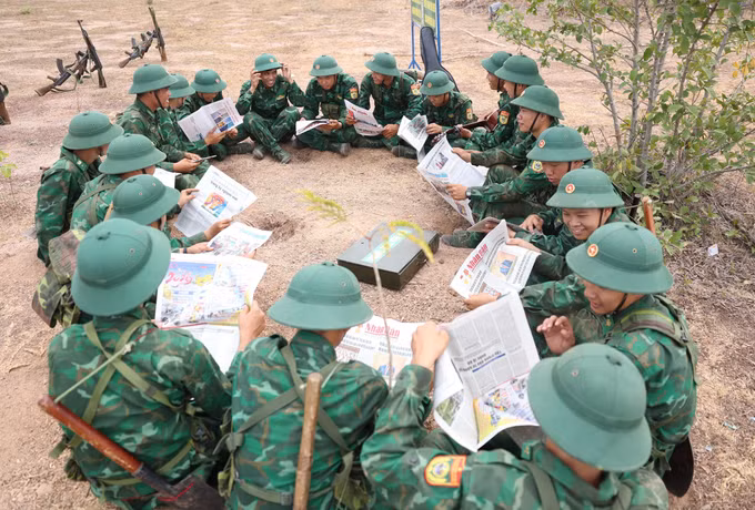 Giờ giải lao trên thao trường, chiến sĩ mới đọc báo và sinh hoạt tập thể.