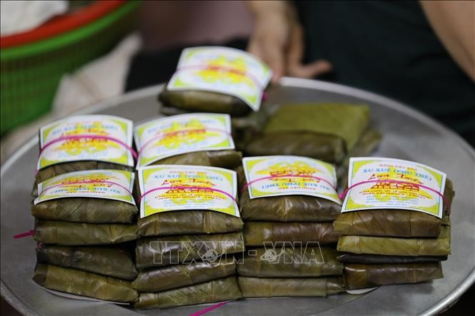 Những cặp bánh buộc lạt giang xinh xắn nằm gọn trong lá xanh, như những lời chúc bình an được gói ghém cẩn thận.