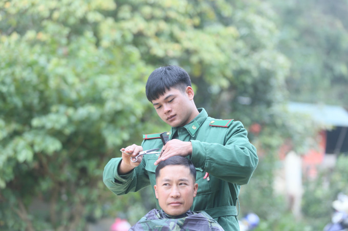 Chiến sĩ Đồn Biên phòng Chiềng Tương cắt tóc miễn phí cho nhân dân.