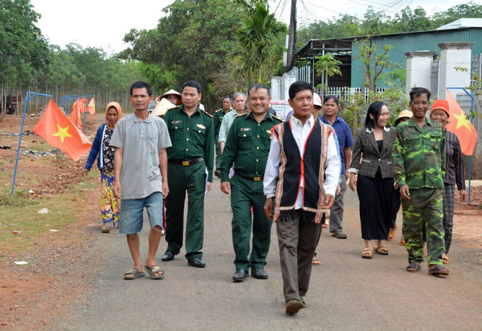 Già làng, người có uy tín trong cộng đồng và lực lượng biên phòng “đi từng ngõ, gõ từng nhà” để hướng dẫn người dân quy trình bỏ phiếu bầu cử đúng theo quy định.