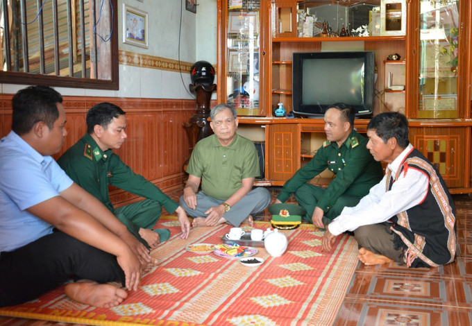 Già làng, người có uy tín trong cộng đồng và lực lượng biên phòng đến từng nhà hướng dẫn người dân quy trình bỏ phiếu bầu cử đúng theo quy định.