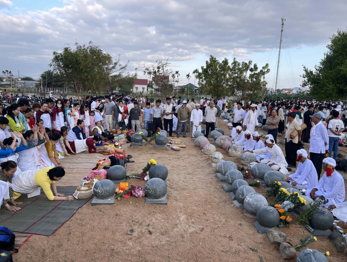 Con, cháu dòng tộc theo đạo Hồi giáo Bàni mặc bộ áo truyền thống thực hiện nghi lễ tảo mộ tại nghĩa trang, mời tổ tiên về chung vui Tết Ramưvan.