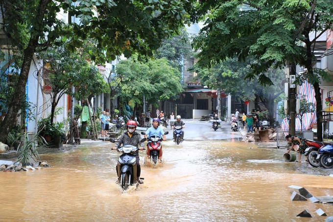 Theo người dân, nguyên nhân nước rút chậm là do một số tuyến đường đang thi công hệ thống cống rãnh. Ảnh: Đinh Thùy/TTXVN ngap-lut-yen-bai-4.jpg
