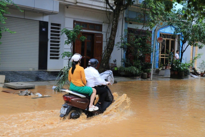 Người dân di chuyển gặp khó khăn do nước rút chậm. Ảnh: Đinh Thùy/TTXVN Người dân di chuyển gặp khó khăn do nước rút chậm. Ảnh: Đinh Thùy/TTXVN