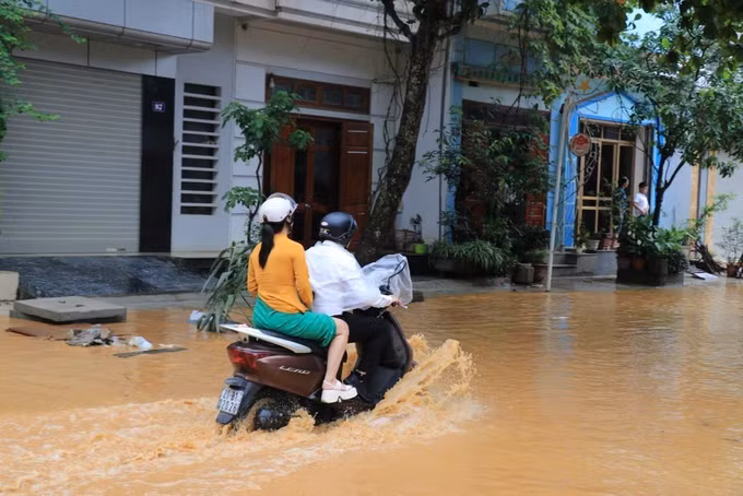 Người dân di chuyển gặp khó khăn do nước rút chậm. Ảnh: Đinh Thùy/TTXVN