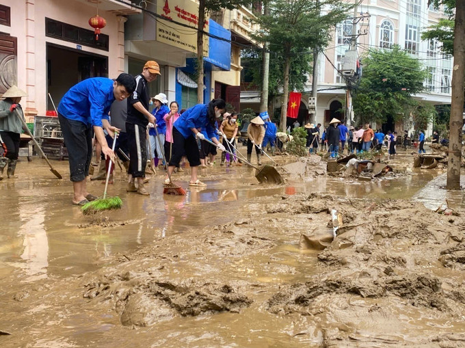 Các lực lượng thanh niên tình nguyện được huy động để giúp dân dọn dẹp nhà ở, vệ sinh đường phố. Ảnh: TTXVN cao-bang-sau-lu.jpg
