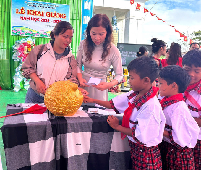 Giáo viên và học sinh trường Tiểu học Kim Đồng, xã Tu Mơ Rông (Quảng Ngãi) bỏ tiền heo đất gây quỹ duy trì bữa ăn trưa miễn phí và hỗ trợ cho những học sinh nghèo, mồ côi không thuộc diện bán trú. Ảnh: TTXVN phát khai-giang-quang-ngai-1.jpg