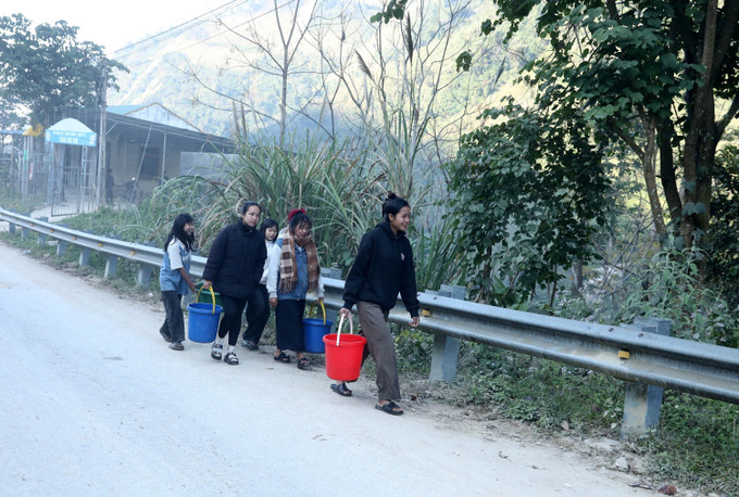Người dân bản Xói Voi xách nước sạch từ giếng khoan về sử dụng.