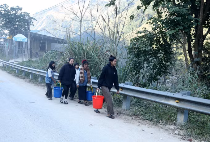 Người dân bản Xói Voi xách nước sạch từ giếng khoan về sử dụng.