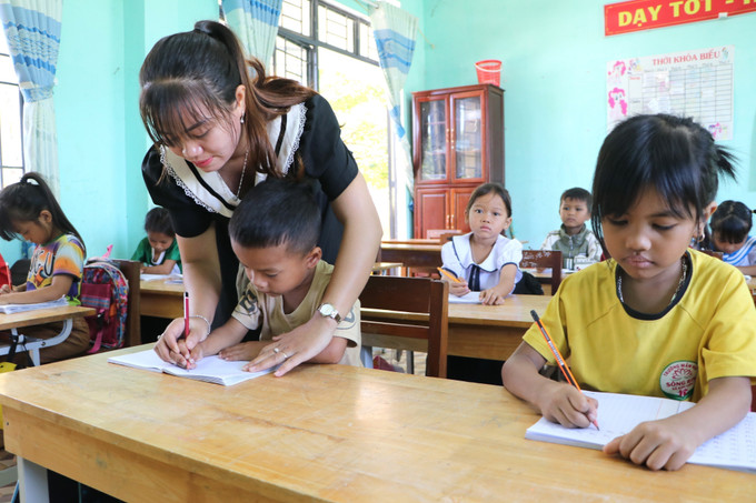 Giáo viên cầm tay hướng dẫn học sinh viết từng nét chữ. Giáo viên cầm tay hướng dẫn học sinh viết từng nét chữ.