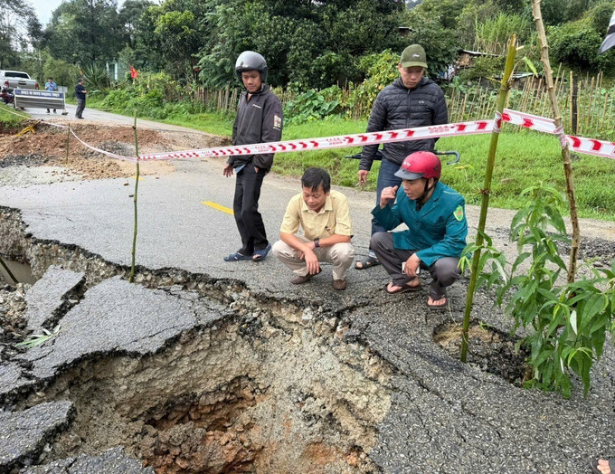 Lực lượng chức năng kiểm tra, chăng dây cảnh báo và bàn phương án xử lý hố tử thần. Ảnh: TTXVN phát sut-lun-quoc-lo-quang-ngai-2.jpg