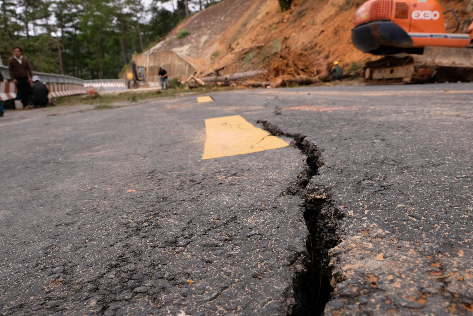 Bên dưới nền đường xuất hiện sụt lún, có nhiều vết nứt lớn, kéo dài khoảng 10m tại phần đường dẫn vào cầu Treo thuộc quốc lộ 20. Ảnh: Nguyễn Dũng/TTXVN
