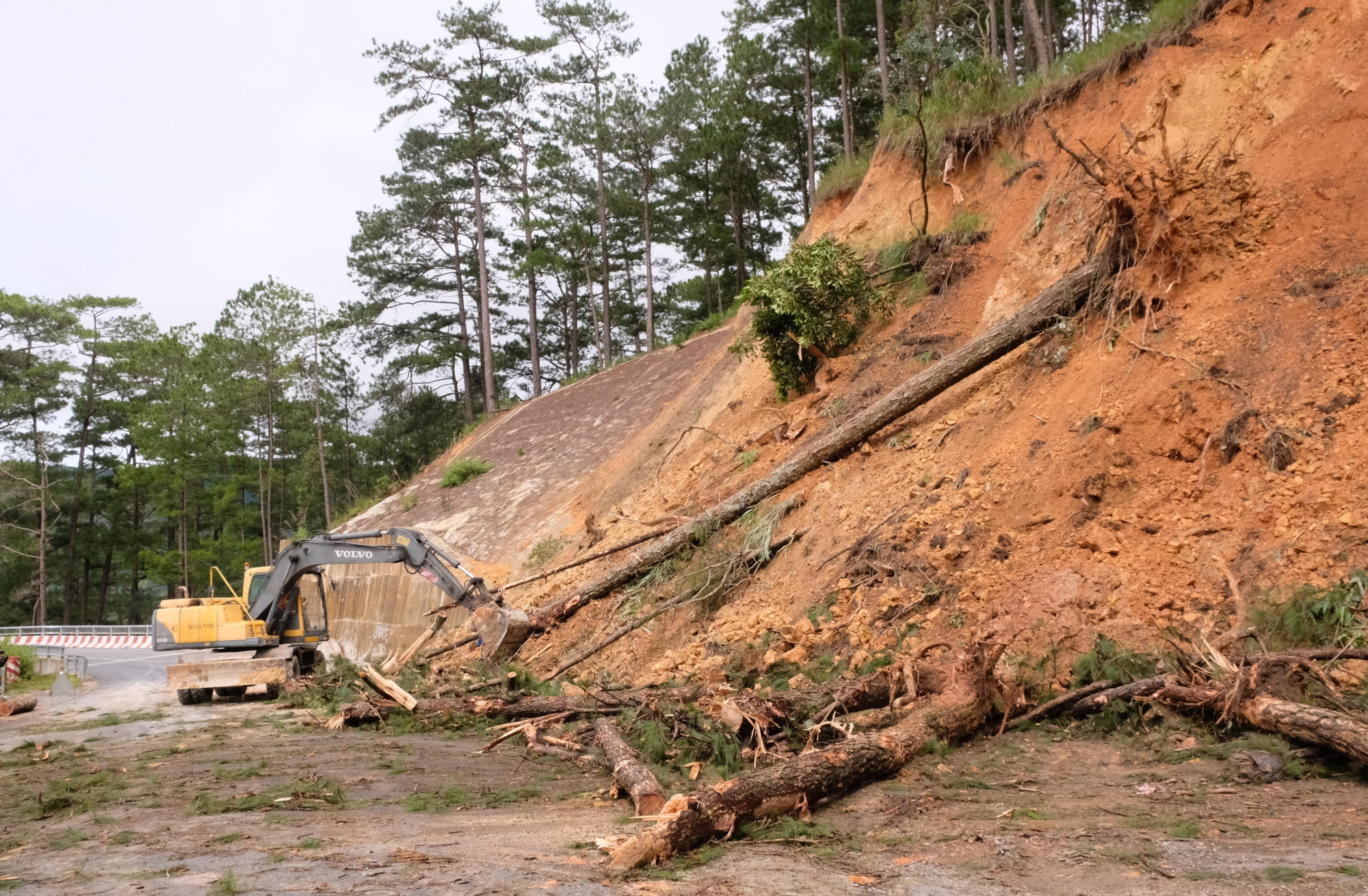 Các phương tiện được huy động để triển khai công tác giải phóng mặt bằng, giải tỏa hiện trường khu vực sạt lở trên đèo D’ran. Ảnh: Nguyễn Dũng/TTXVN
