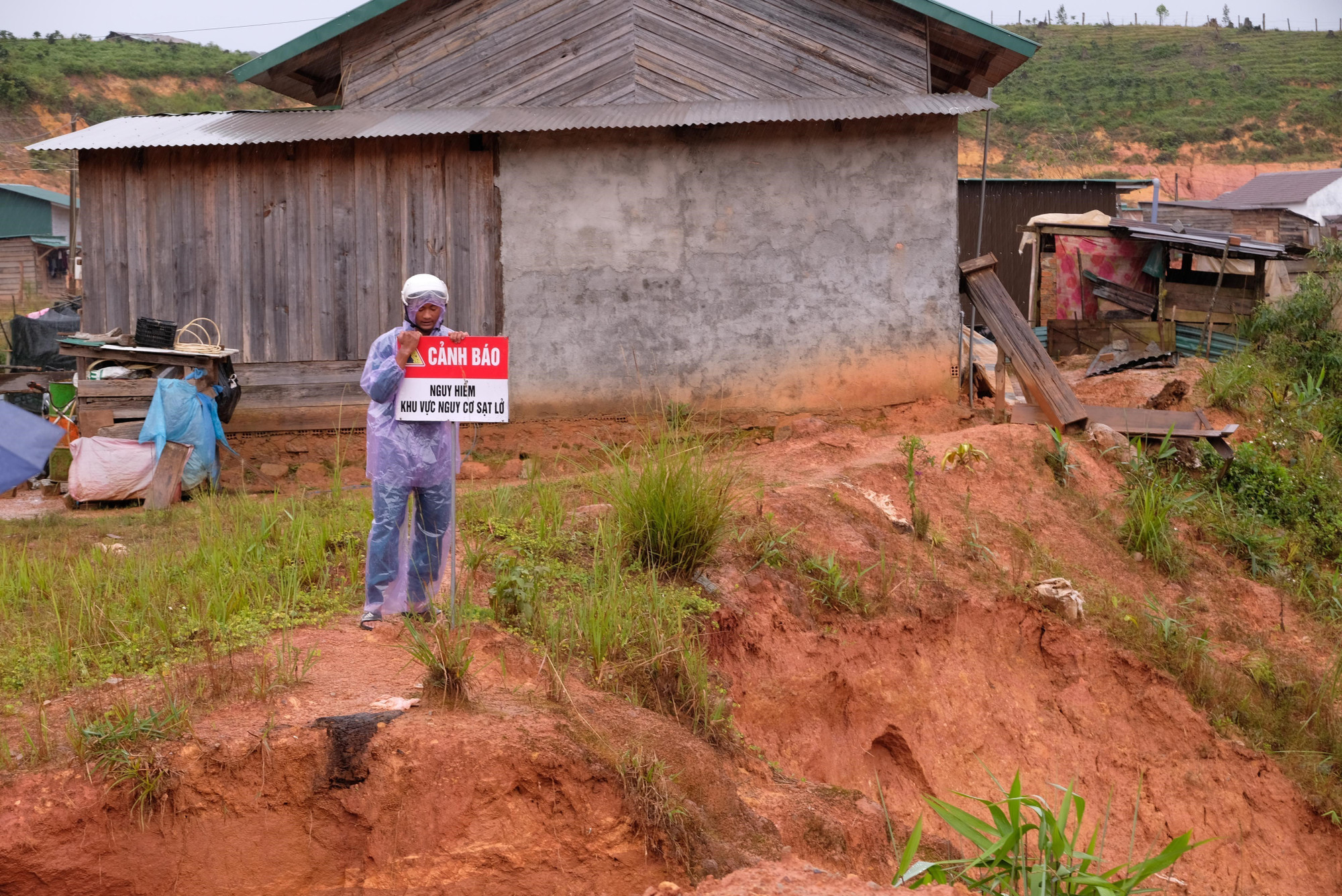 Lực lượng chức năng xã Đam Rông 4 cắm biển cảnh báo sạt lở tại khu tái định cư ở thôn K’Nớ 5 sáng 16/10.
