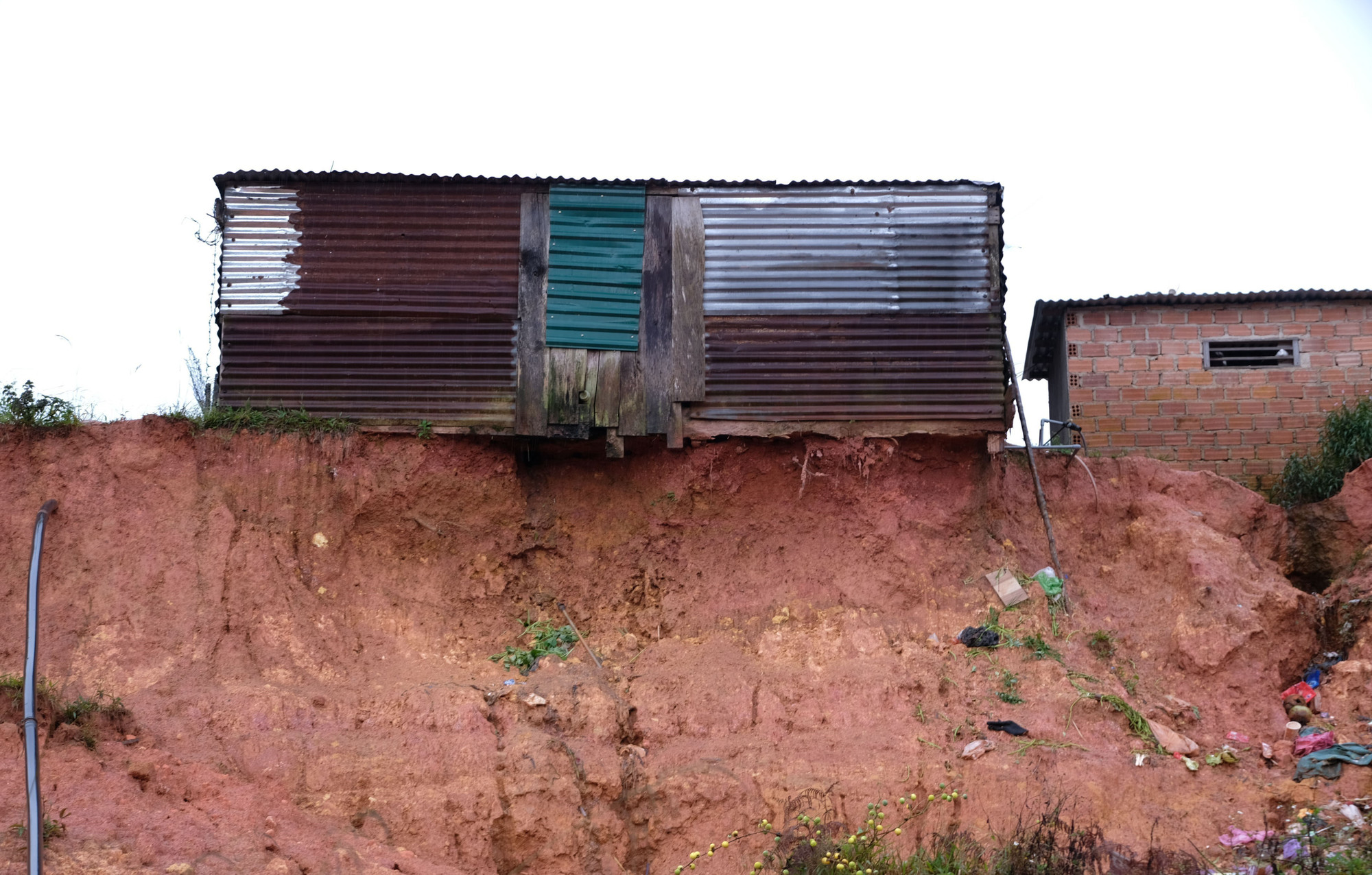 Một nhà dân trong khu dân cư thôn K’Nớ 5 bị sạt lở “ăn” sát tới chân móng của công trình phụ.