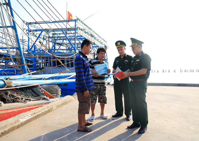Cán bộ, chiến sĩ trạm kiểm soát Biên phòng Pháo Đài, Đồn Biên phòng Cửa khẩu Quốc tế Hà Tiên (Bộ đội Biên phòng tỉnh Kiên Giang) kiểm tra giấy tờ tàu cá nhập bến. Ảnh: Hồng Đạt – TTXVN Vững vàng nơi tiền đồn Tây Nam Tổ quốc (Bài 2) ảnh 2