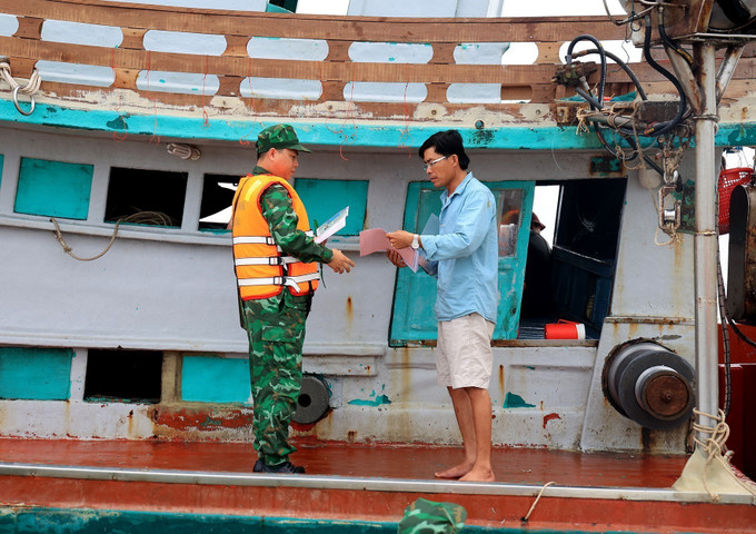 Cán bộ biên phòng Đồn Biên phòng Sông Đốc (Bộ đội Biên phòng tỉnh Cà Mau) kiểm tra tàu cá, phòng chống khai thác IUU. Ảnh: Hồng Đạt – TTXVN Vững vàng nơi tiền đồn Tây Nam Tổ quốc (Bài 3) ảnh 2