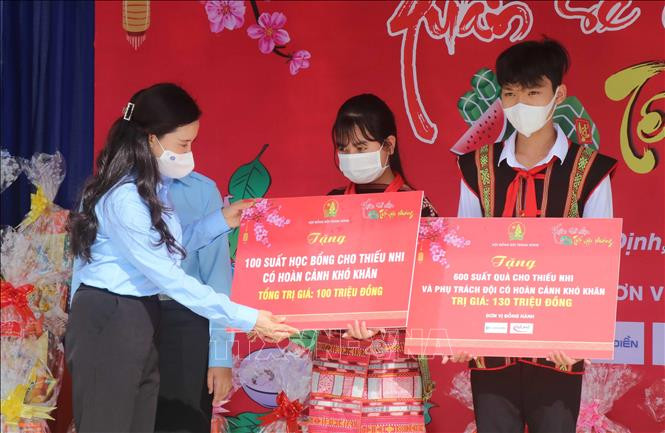Bí thư Trung ương Đoàn, Chủ tịch Hội đồng đội trung ương trao Nguyễn Phạm Duy Trang trao bảng tượng trưng học bổng và quà Tết cho các em học sinh huyện Vân Canh. Ảnh: Phạm Kha – TTXVN. Tết Nhâm Dần 2022: Chương trình “Tết ấm cho em - Lễ hội gói bánh chưng” ảnh 3