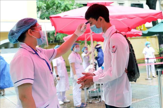 Cán bộ y tế sẽ hỗ trợ đo thân nhiệt cho thí sinh, cán bộ làm công tác thi khi tới điểm thi. Ảnh: Thanh Tùng - TTXVN Kỳ thi tốt nghiệp THPT năm 2021: Hà Nội hướng dẫn chi tiết phòng, chống dịch COVID-19, đảm bảo an toàn cho kỳ thi ảnh 1