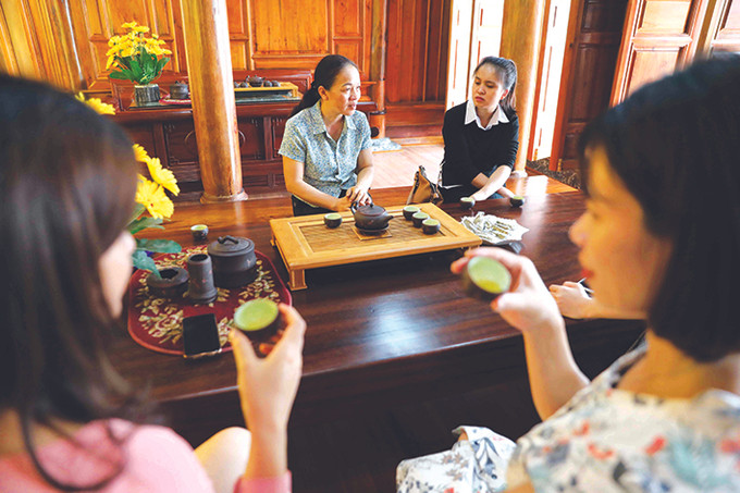 Du khách được gia chủ mời thưởng thức chén trà thơm ngon trong một không gian thưởng trà độc đáo, ấm cúng, chia sẻ kinh nghiệm làm chè và lịch sử phát triển của cây chè Tân Cương. Ảnh: Thanh Tùng Tân Cương phát triển du lịch cộng đồng gắn với không gian văn hóa trà ảnh 2