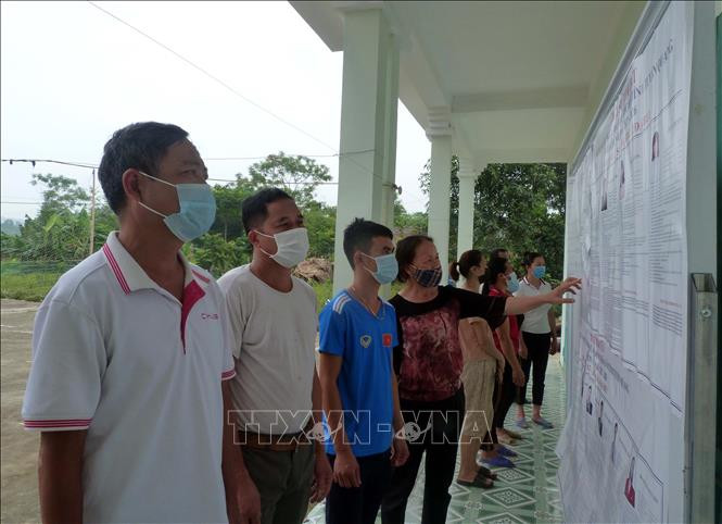 Người dân thôn Đồng Mà, xã Trung Yên, huyện Sơn Dương (Tuyên Quang) tìm hiểu thông tin về các ứng cử viên được niêm yết tại nhà văn hóa thôn. Ảnh: Vũ Quang – TTXVN Bầu cử QH và HĐND: Thủ đô kháng chiến hướng về “Ngày hội non sông” ảnh 1