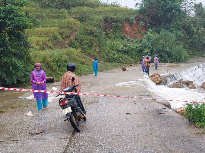 Người dân và lực lượng chức năng xã Măng Ri huyện Tu Mơ Rông (Kon Tum) phối hợp, hỗ trợ cho người và phương tiện đi qua các điểm ngập. Ảnh: TTXVN phát Kon Tum: Khắc phục tình trạng chia cắt, cô lập các xã ở huyện Tu Mơ Rông do sạt lở ảnh 1