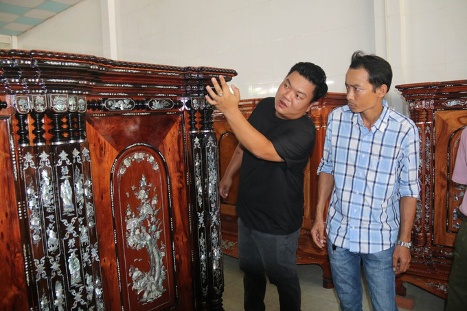 Khách mua ấn tượng trước chiếc tủ thờ Gò Công độc đáo. Ảnh: Minh Trí – TTXVN Độc đáo làng nghề tủ thờ Gò Công trên 100 năm tuổi ảnh 9