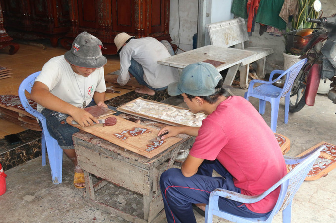 Việc chạm khắc đòi hỏi sự tỉ mỉ và lành nghề. Ảnh: Minh Trí – TTXVN Độc đáo làng nghề tủ thờ Gò Công trên 100 năm tuổi ảnh 5