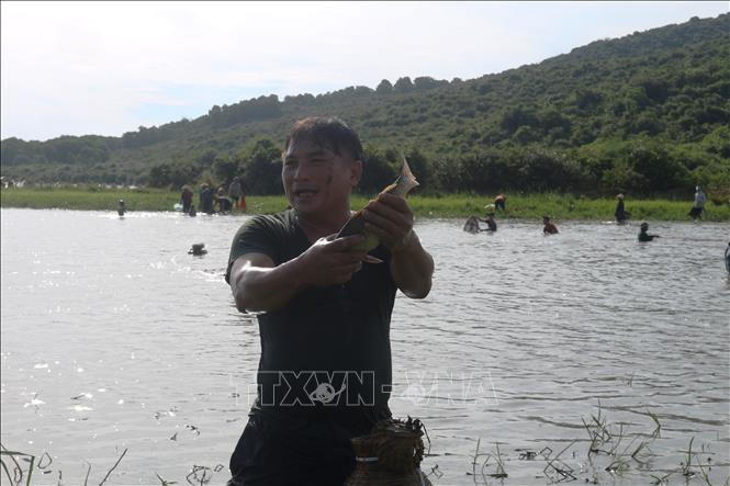 Khi một người bắt được con cá to thì hú lên để những người xung quanh hò reo chúc mừng, cổ vũ. Ảnh: Hoàng Ngà - TTXVN Độc đáo lễ hội đánh cá Đồng Hoa ảnh 5