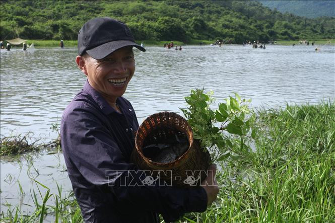 Niềm vui của người dân khi bắt được nhiều cá bởi theo quan niệm, ai bắt được nhiều cá và cá to thì sẽ làm ăn may mắn trong suốt cả năm. Ảnh: Hoàng Ngà – TTXVN Độc đáo lễ hội đánh cá Đồng Hoa ảnh 4